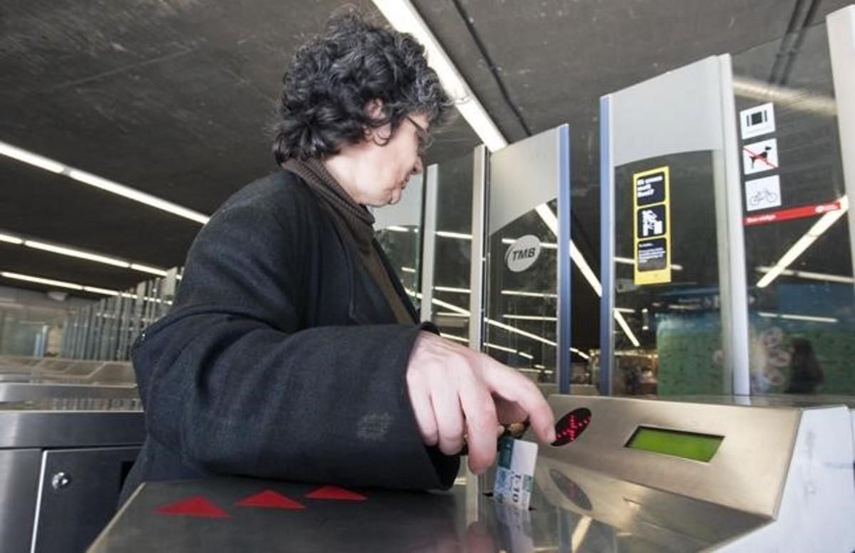Una mujer valida su billete en una estación de metro de Barcelona. Una mujer valida su billete en una estación de metro de Barcelona.