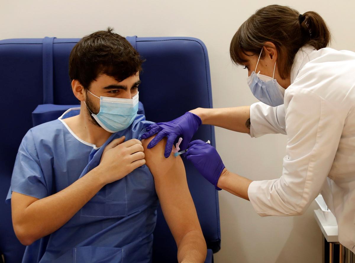 Una enfermera del Hospital Clinic de Barcelona administra la primera dosis de la vacuna Pfizer-BioNTech a un sanitario en la campaña de vacunación del propio hospital a su personal.