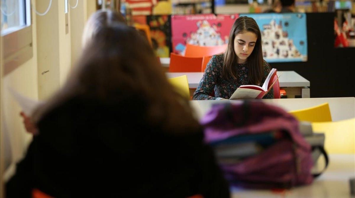 Dos adolescentes leen libros en la biblioteca de Poblenou Manuel Arranz. Dos adolescentes leen libros en la biblioteca de Poblenou Manuel Arranz.