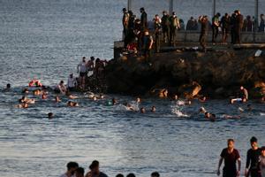 Personas migrantes caminan por la playa del Tarajal, en Ceuta, el pasado 17 de mayo de 2021. 