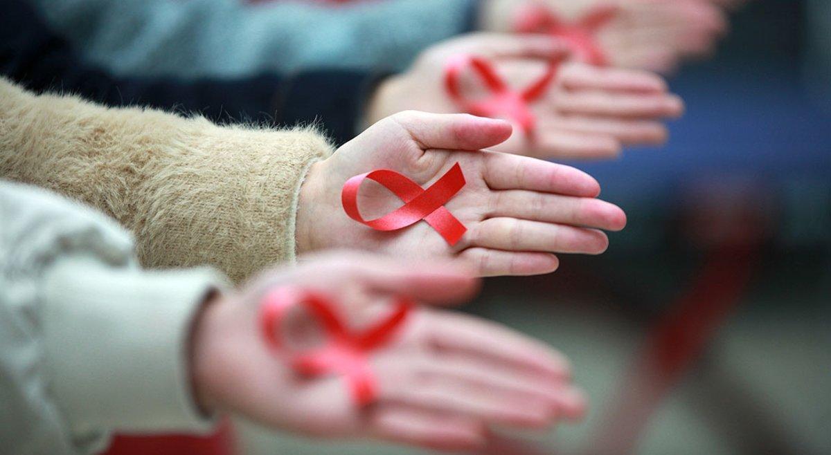 Estudiantes de la Universidad de Yangzhou (China) muestran cintas rojas para promover la prevención del sida, ayer.