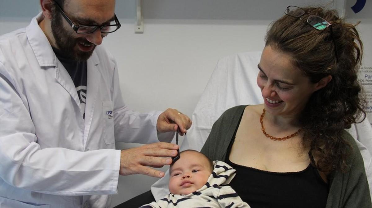 El investigador del Institut de Ciencies Fotòniques (ICFO) Turgut Durduran aplica a un bebé el dispositivo para infantes prematuros Babylux.