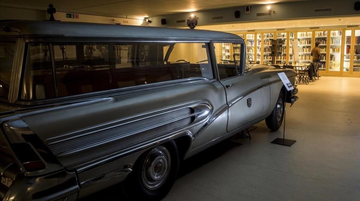 Al fondo, Adrià Terol consulta unos libros en la biblioteca funeraria instalada en el cementerio de Montjuïc, junto a la colección de carrozas fúnebres. En primer plano, un Buick del 58 con su ataúd. Al fondo, Adrià Terol consulta unos libros en la biblioteca funeraria instalada en el cementerio de Montjuïc, junto a la colección de carrozas fúnebres. En primer plano, un Buick del 58 con su ataúd.
