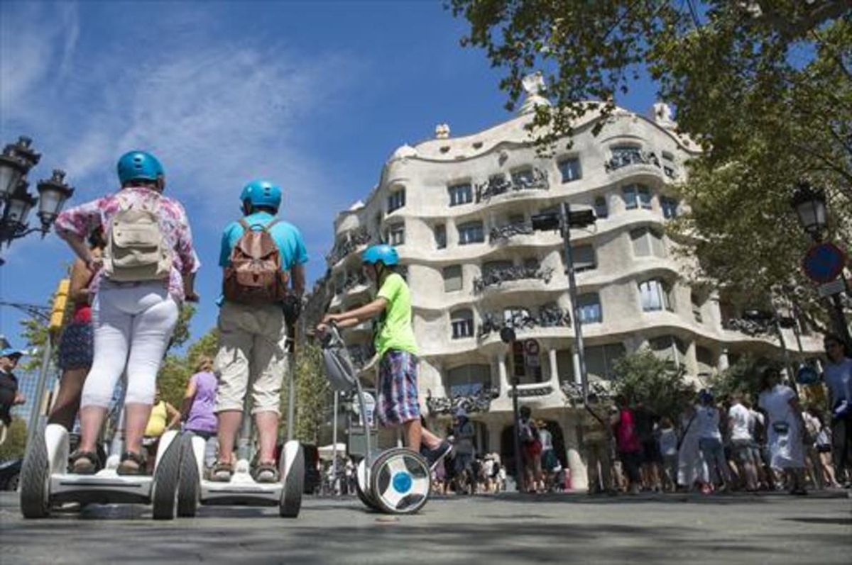 Turistas sobre ’segways’ frente a La Pedrera, en Barcelona. Turistas sobre ’segways’ frente a La Pedrera, en Barcelona.
