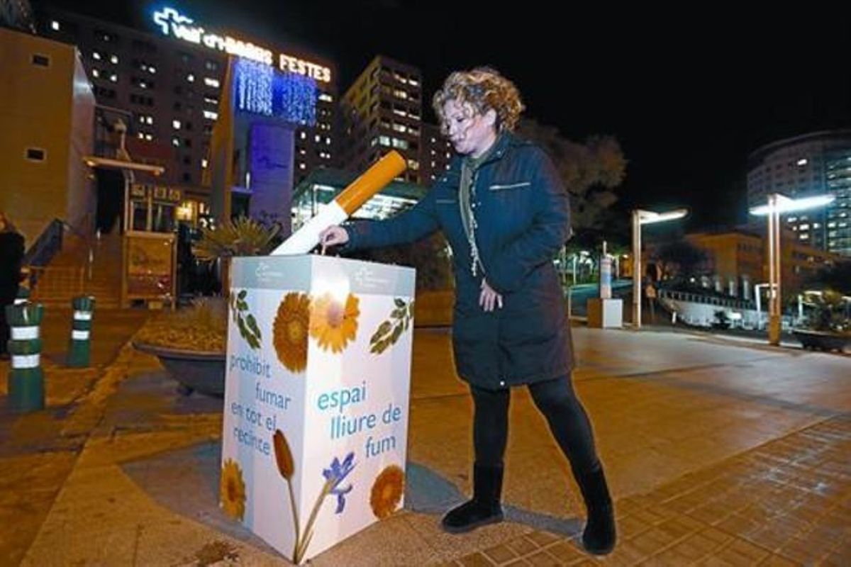 Una mujer apaga un cigarrillo en uno de los puntos habilitados por el Hospital Vall d’Hebron, junto a la Ronda de Dalt de Barcelona, ayer. Una mujer apaga un cigarrillo en uno de los puntos habilitados por el Hospital Vall d’Hebron, junto a la Ronda de Dalt de Barcelona, ayer.