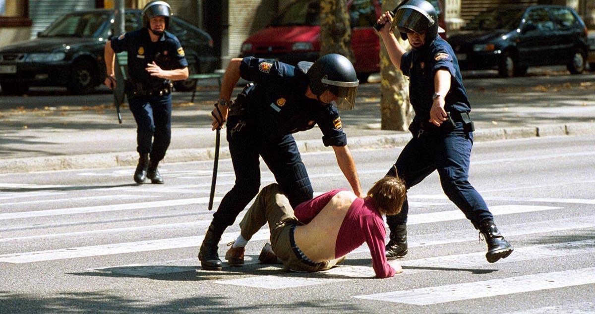 Uno de los participantes en la manifestación antiglobalización convocada en Barcelona en junio de 2001 es retenido por un par de agentes de Mossos d’Esquadra.