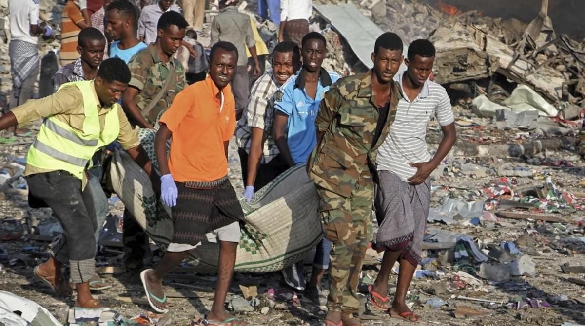 Traslado de un cadáver del lugar donde se ha producido uno de los atentados con bomba en Mogadiscio. Traslado de un cadáver del lugar donde se ha producido uno de los atentados con bomba en Mogadiscio.