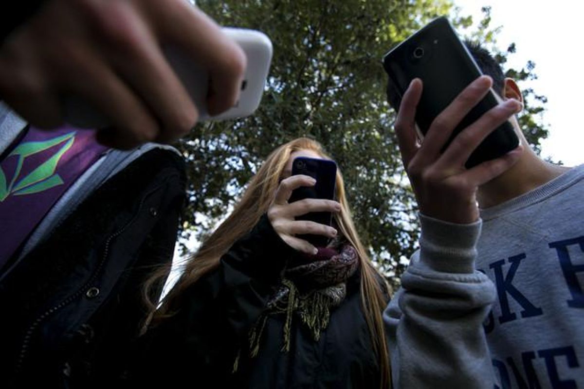 Un grupo de adolescentes utilizando sus ’smartphones’. Un grupo de adolescentes utilizando sus ’smartphones’.