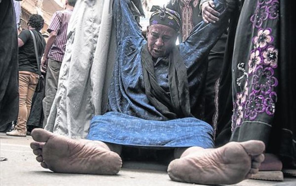 Unos egipcios ayudan a una mujer conmocionada por la sentencia de la pena de muerte decretada ayer por un tribunal egipcio en la ciudad de Minia. Unos egipcios ayudan a una mujer conmocionada por la sentencia de la pena de muerte decretada ayer por un tribunal egipcio en la ciudad de Minia.
