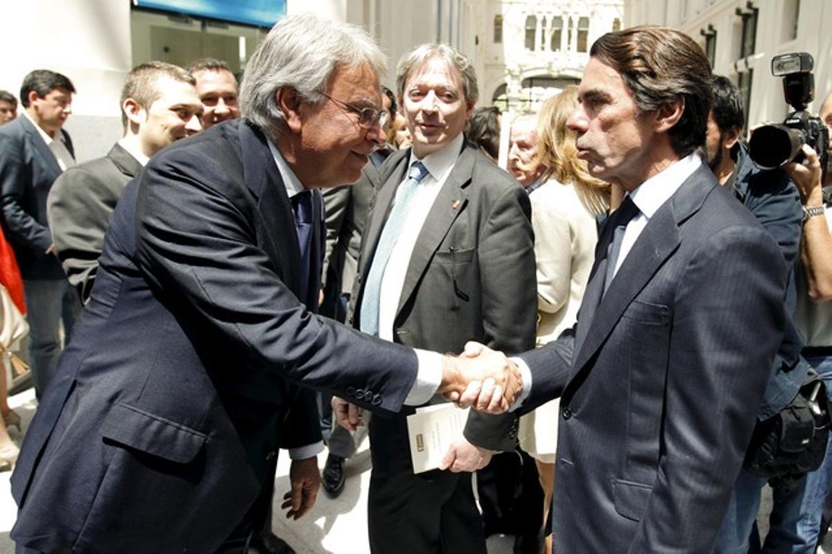 González y Aznar se saludan a su llegada al acto.