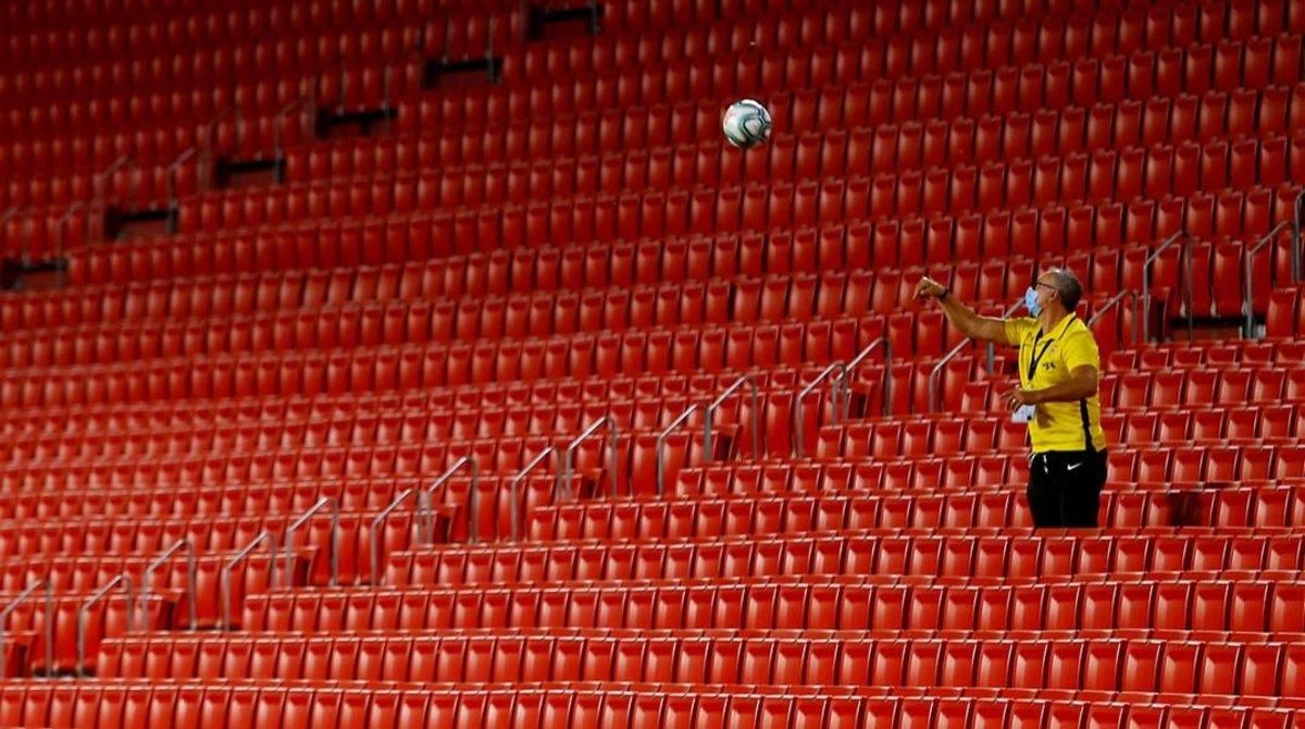 Un empleado del Sevilla devuelve una pelota al césped desde la tribuna vacía en el reciente Sevilla-Barça (0-0). Un empleado del Sevilla devuelve una pelota al césped desde la tribuna vacía en el reciente Sevilla-Barça (0-0).