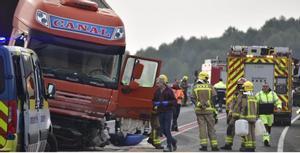 El camió accidentado y los servicios de emergencia.