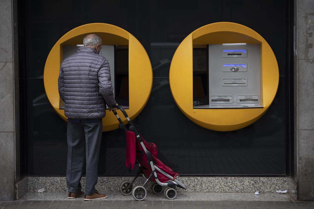 Un jubilado delante de un cajero automático, en Barcelona.