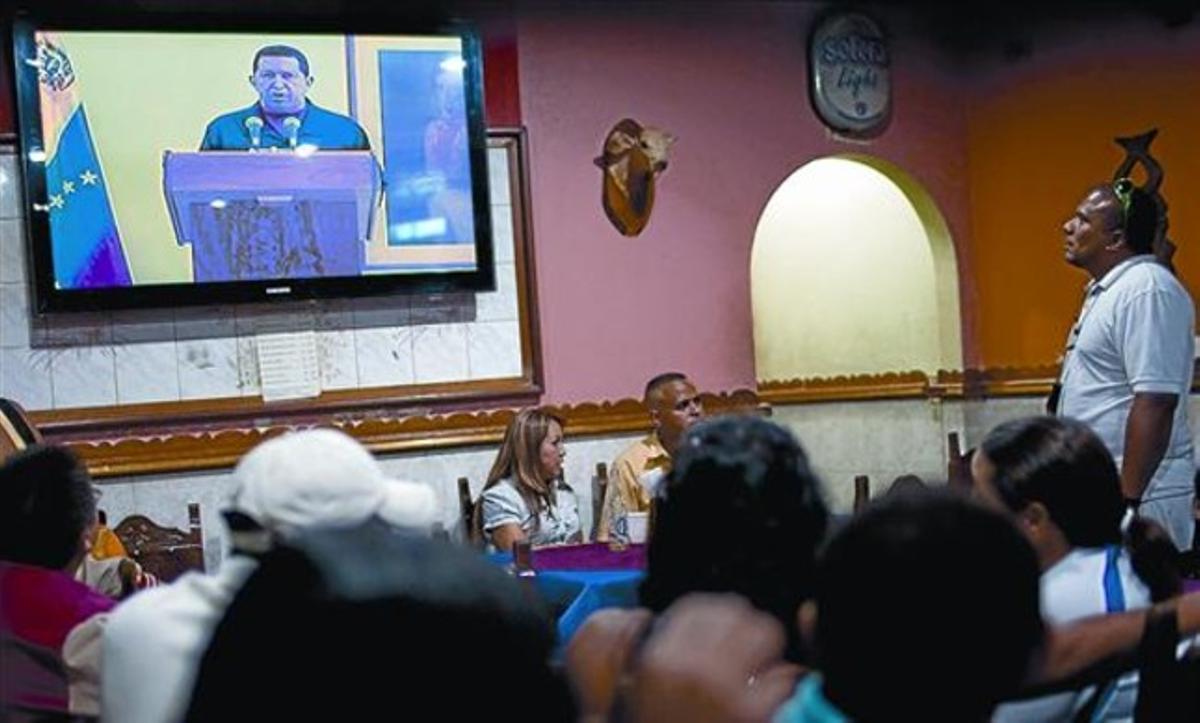 Clientes de un bar en Caracas siguen el discurso televisado de Chávez, ayer. Clientes de un bar en Caracas siguen el discurso televisado de Chávez, ayer.