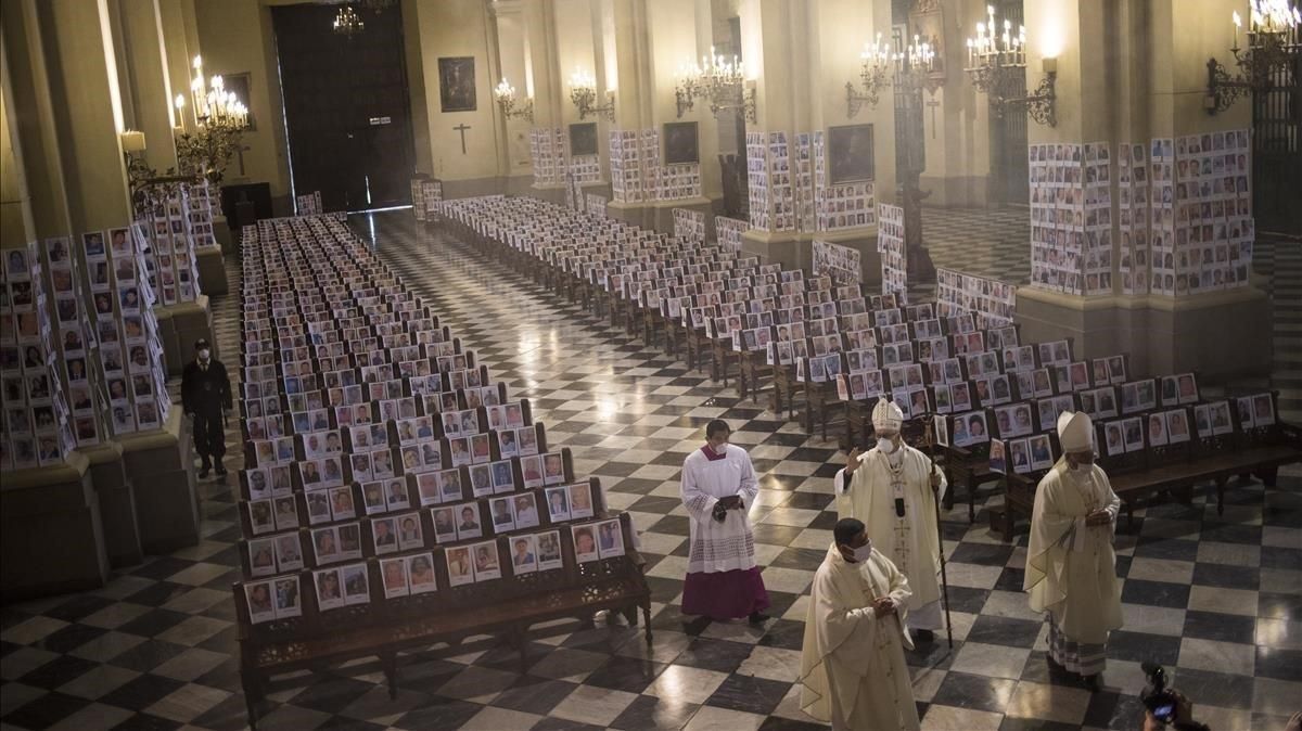 El arzobispo de Lima bendice a víctimas del covid-19, representados con fotografías en la catedral. El arzobispo de Lima bendice a víctimas del covid-19, representados con fotografías en la catedral.
