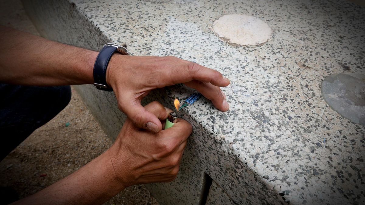 Un hombre enciende un petardo. Un hombre enciende un petardo.