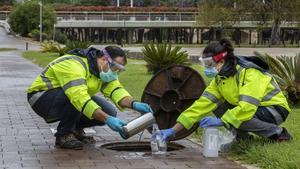Técnicos recogen una muestra de aguas residuales para rastrear el COVID-19 en València