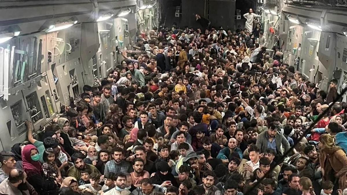 Evacuados agolpados en el interior de un avión de transporte C-17 Globemaster III de la Fuerza Aérea de los EE. UU., que transportaba a unos 640 afganos a Qatar desde Kabul.