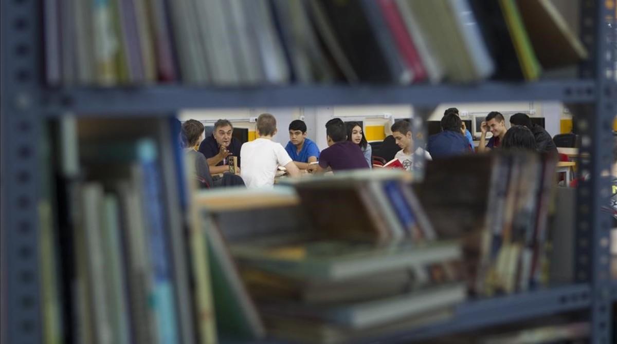 Un grupo de alumnos escucha a su profesor en la biblioteca del instituto Besòs de Barcelona.