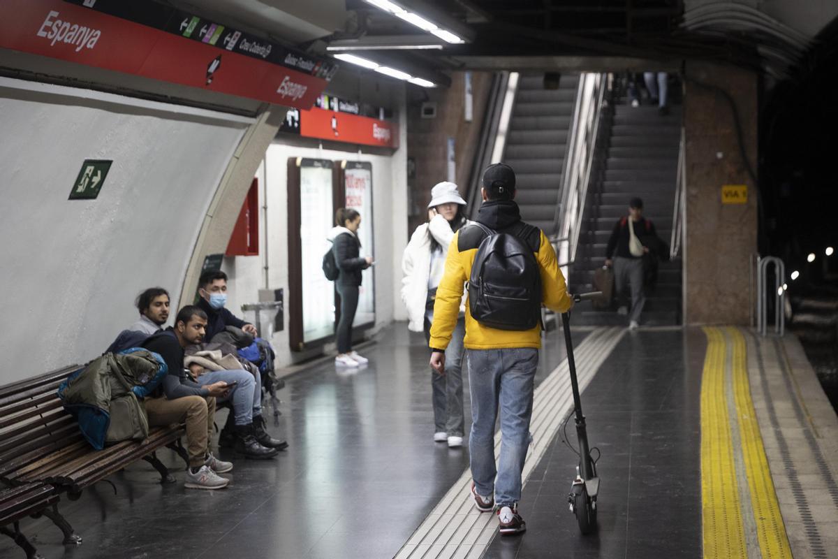 Un usuario de patinete eléctrico en la estación de metro de plaza Espanya en Barcelona