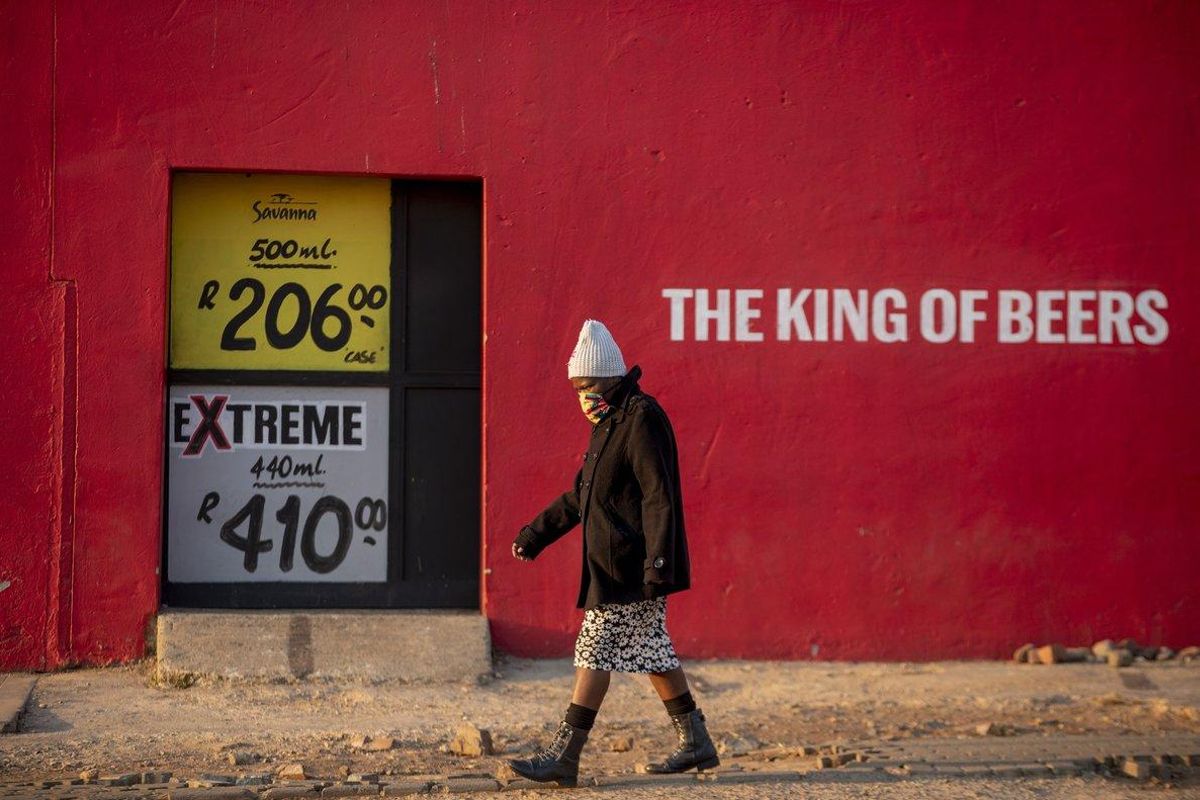 Una mujer pasa por delante de un comercio cerrado de venta de alcohol, en Soweto. Una mujer pasa por delante de un comercio cerrado de venta de alcohol, en Soweto.