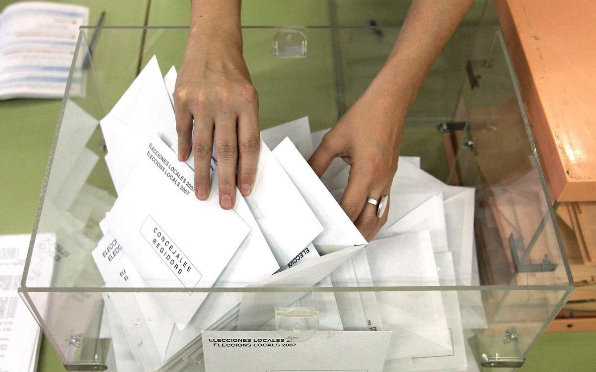 La presidenta de una mesa electoral coge una papeleta durante el recuento de votos