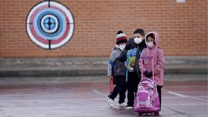 Niños en el patio de una escuela, a su entrada al centro.