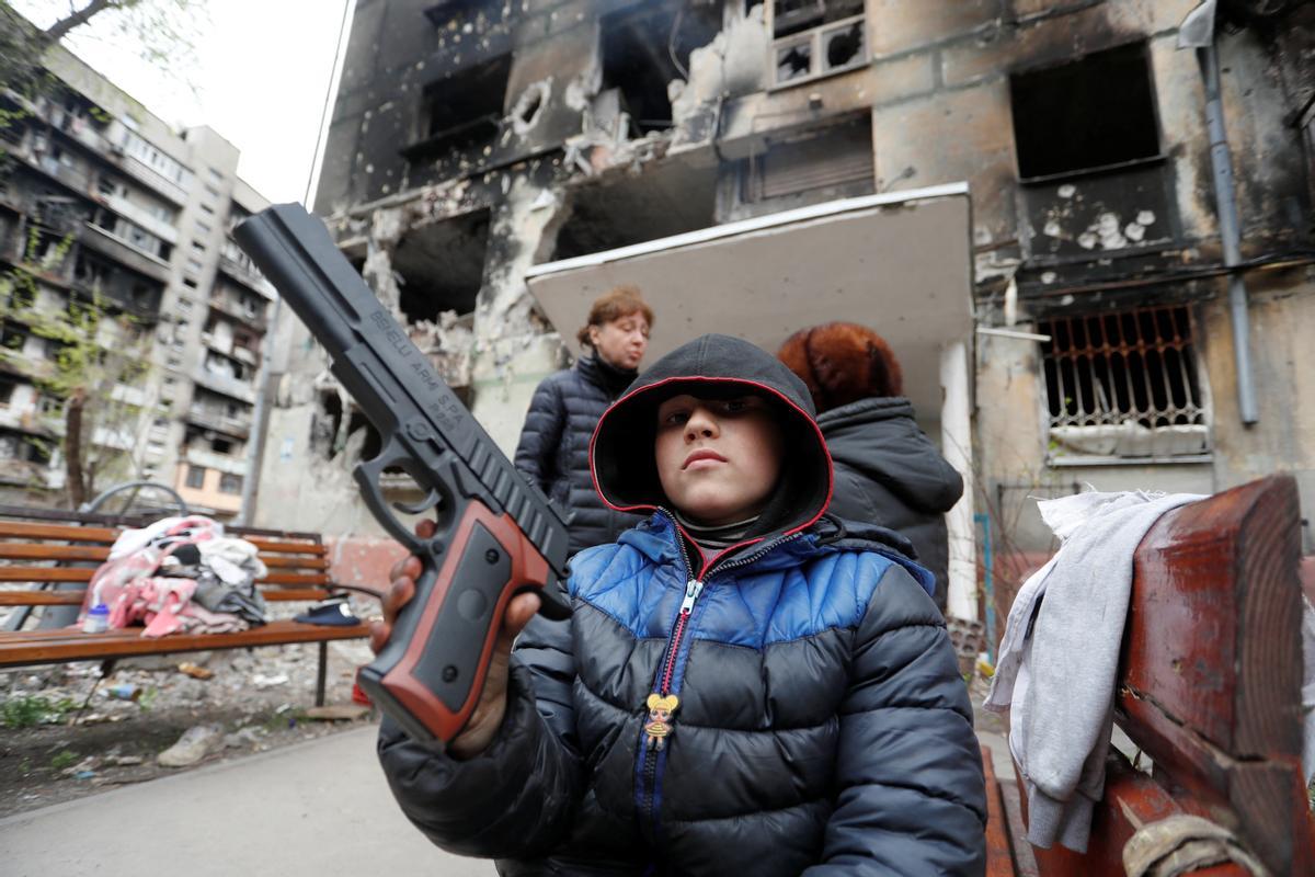 Un niño local juega con una pistola de juguete en la ciudad ucraniana de Mariúpol. 