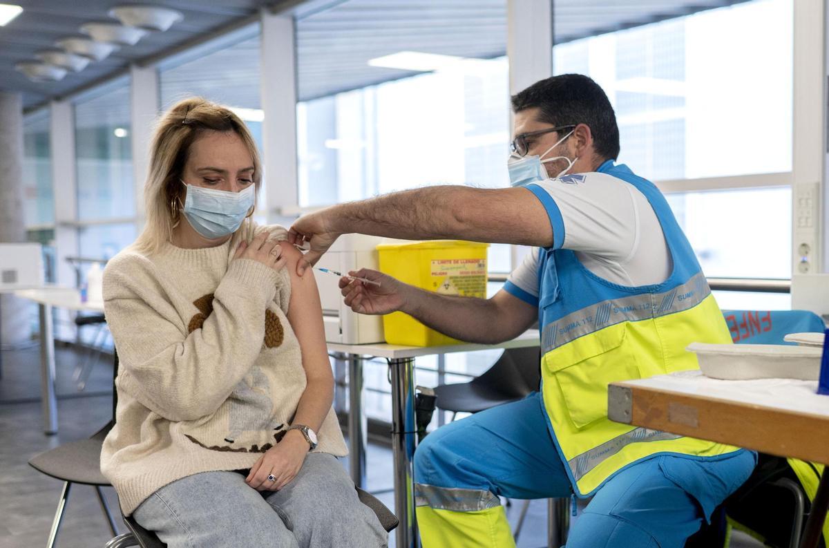 Un sanitario administra una vacuna contra el coronavirus a una mujer en Madrid.