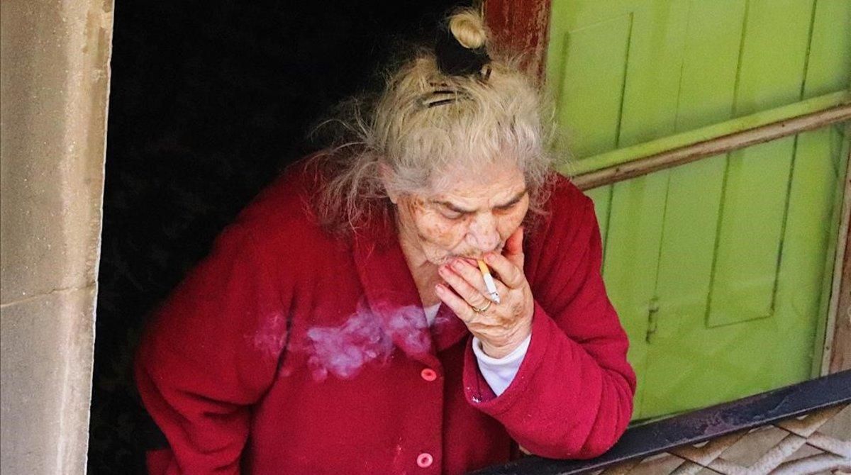 Una señora sale a fumar a su balcón, en una imagen captada por Joel Codina, en el Raval. Una señora sale a fumar a su balcón, en una imagen captada por Joel Codina, en el Raval.
