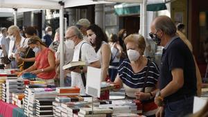 Lectores ante los estands de libros en el paseo de Gràcia de Barcelona, este jueves. 