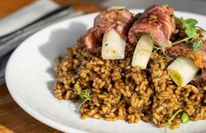 Ca la Nuri Platja ofrece varios platos, como este arroz de secreto ibérico con ’calçots’.