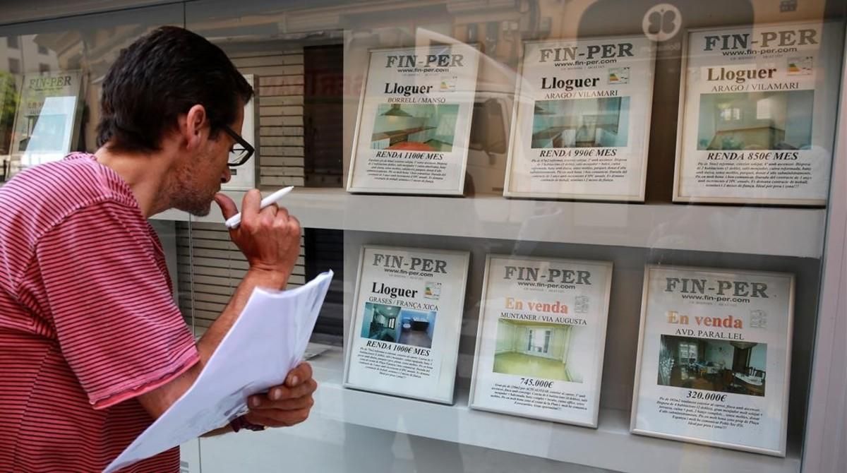 Un hombre busca piso en una agencia inmobiliaria del Poble Sec. Un hombre busca piso en una agencia inmobiliaria del Poble Sec.