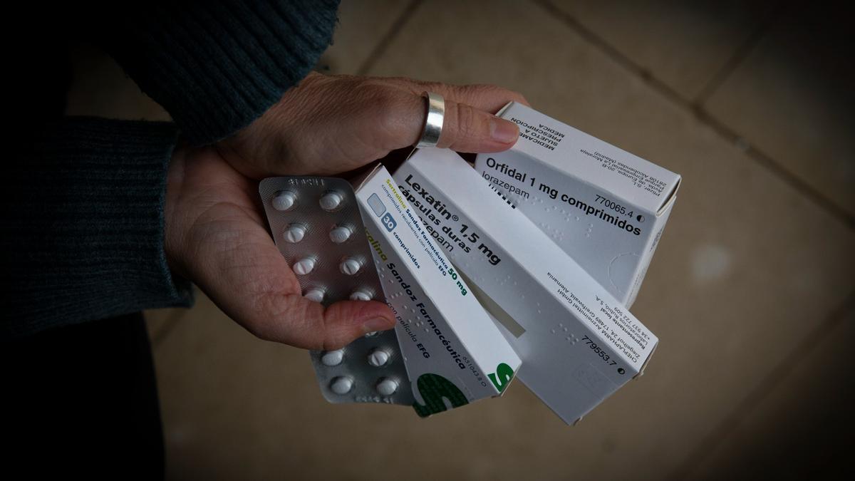 Una persona sujeta varias cajas de medicamentos, una de ellas de Orfidal (Lorazepam)