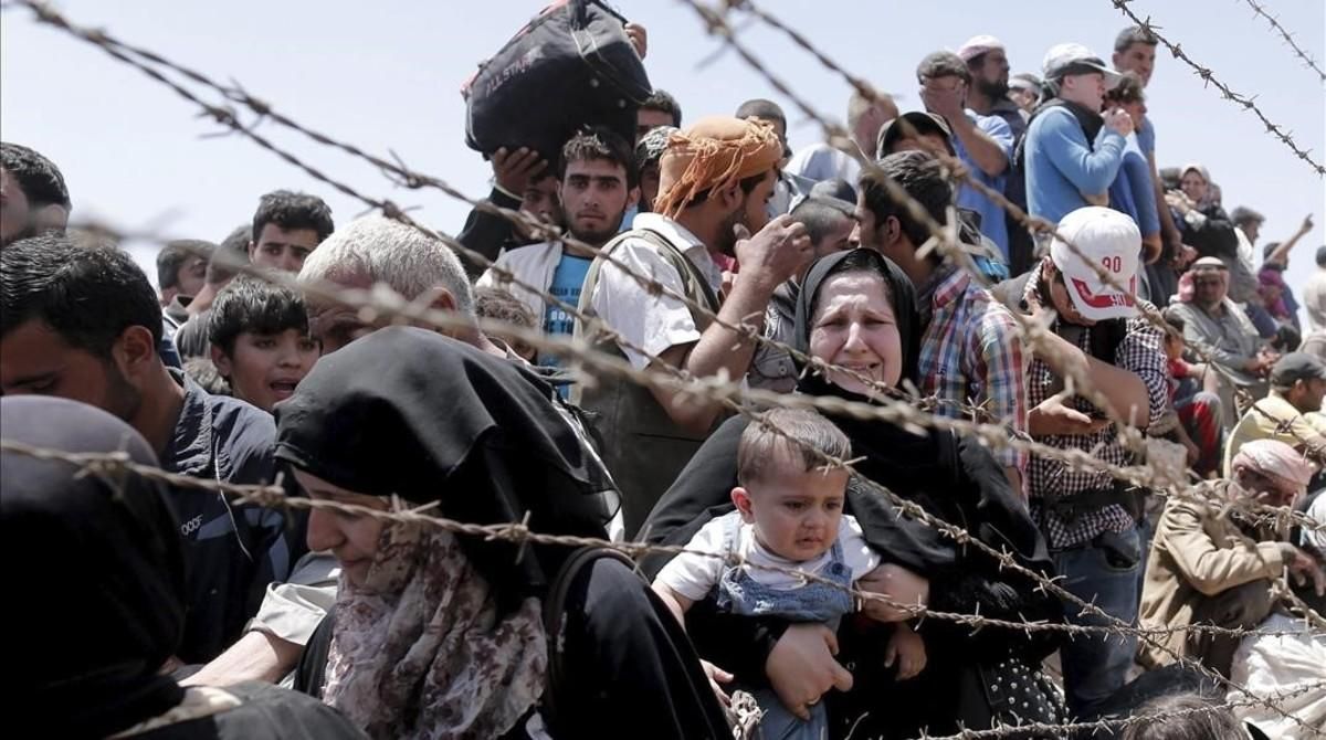 Refugiados sirios esperan cruzar desde su país la frontera que les separa de Turquía cerca de Akcakale en la provincia de Sanliurfa. Refugiados sirios esperan cruzar desde su país la frontera que les separa de Turquía cerca de Akcakale en la provincia de Sanliurfa.