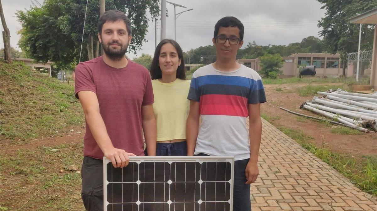 Los estudiantes de la UPC (desde la izq.) Biel Perelló, Cristina Casals y Santiago Enciso, con una de las placas solares que estan instalando en Sunyani (Ghana) en el marco de un proyecto de cooperacion.