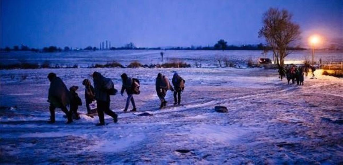 Migrantes y refugiados caminan por un campo cubierto de nieve tras cruzar la frontera de Macedonia con Serbia, cerca de la población de Miratovac, este domingo. Migrantes y refugiados caminan por un campo cubierto de nieve tras cruzar la frontera de Macedonia con Serbia, cerca de la población de Miratovac, este domingo.