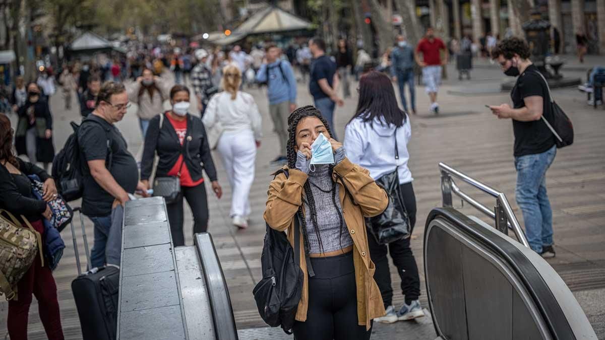 Una mujer se coloca la mascarilla antes de entrar en el metro, en La Rambla de Barcelona. Una mujer se coloca la mascarilla antes de entrar en el metro, en La Rambla de Barcelona.