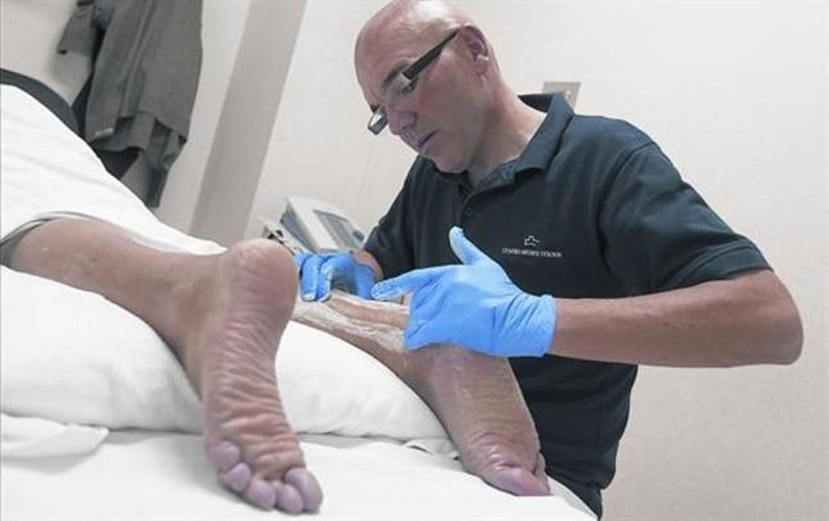 MASAJE FISIOTERAPÉUTICO.Huélamo aplica una friega en la zona afectada por una tendinitis de Aquiles posquirúrgica. MASAJE FISIOTERAPÉUTICO.Huélamo aplica una friega en la zona afectada por una tendinitis de Aquiles posquirúrgica.