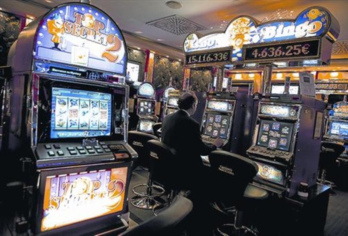 Un hombre juega en las máquinas tragaperras del Casino de Barcelona. Un hombre juega en las máquinas tragaperras del Casino de Barcelona.