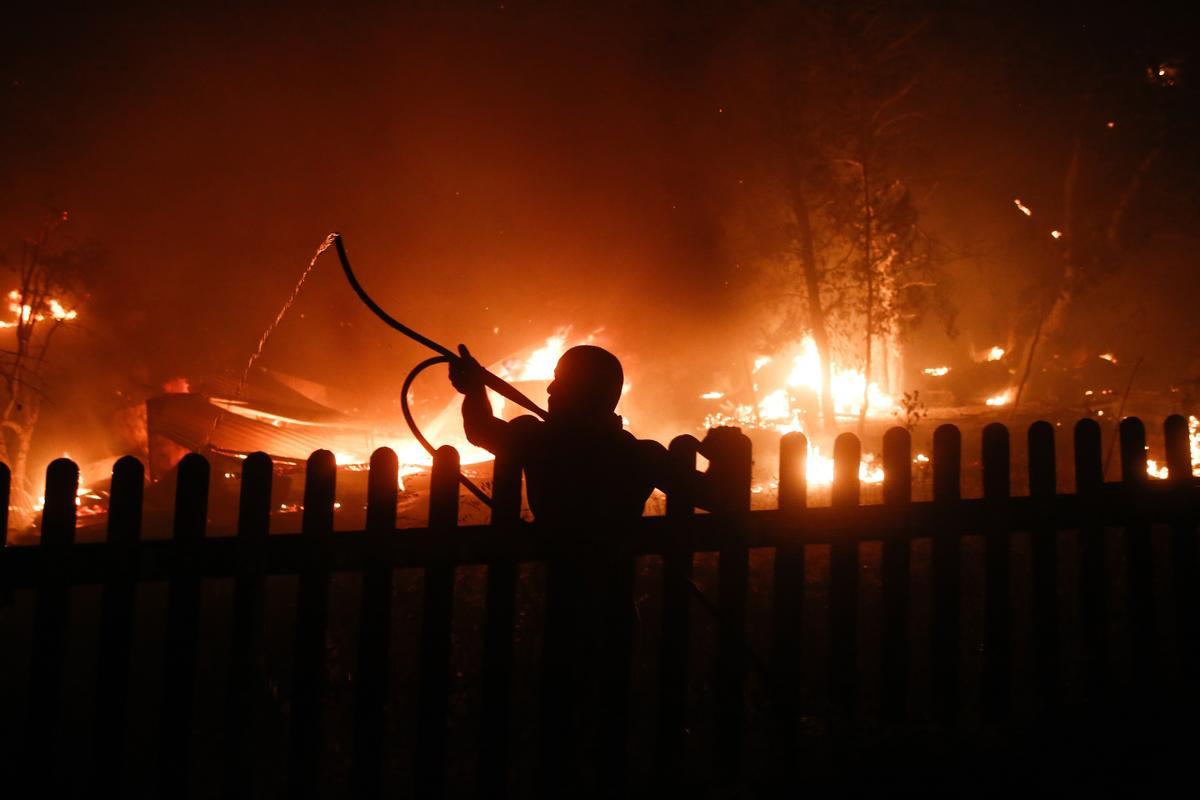 Un vecino lucha contra el fuego en Varybobi, al noreste de Atenas.