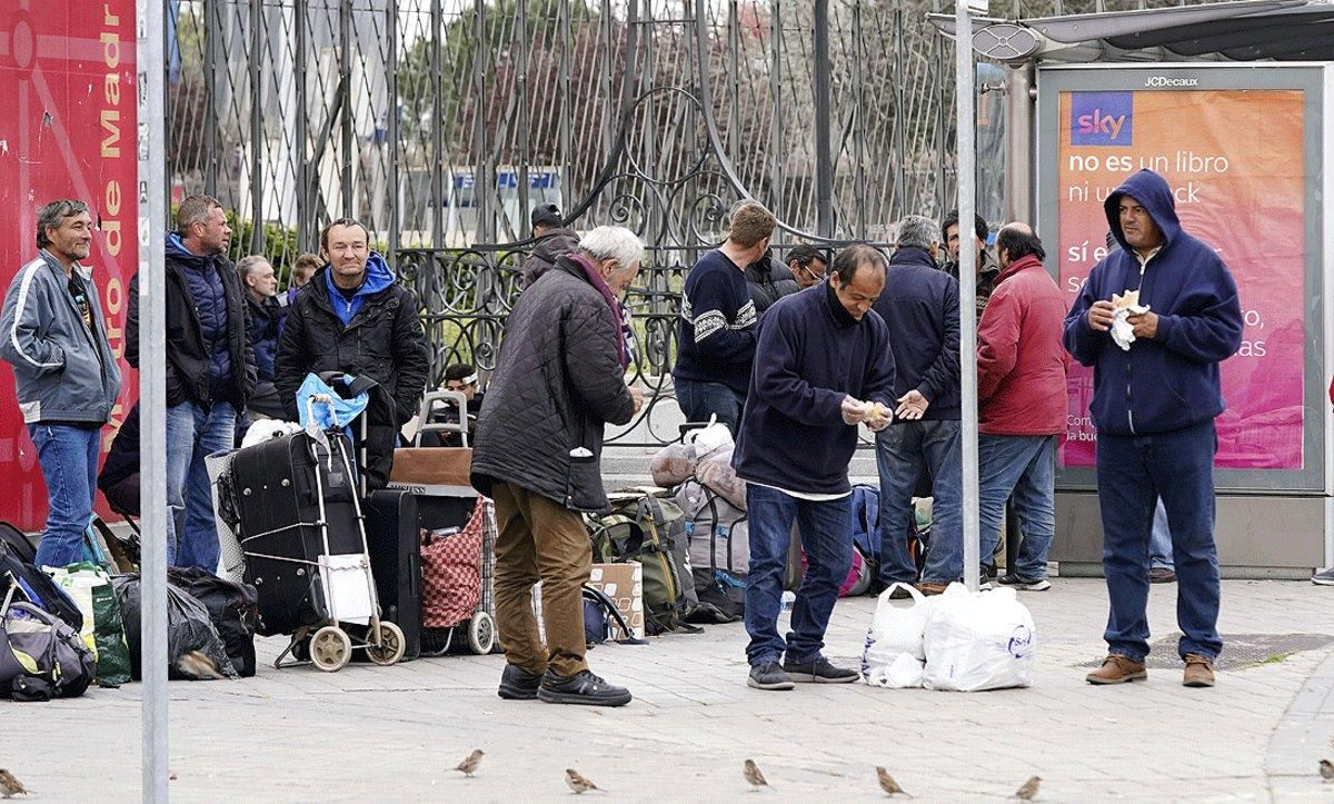 Un grupo de sintecho esperan ante Ifema la apertura del pabellon habilitado para personas sin vivienda mientras dure el confinamiento, el 20 de marzo. Un grupo de sintecho esperan ante Ifema la apertura del pabellon habilitado para personas sin vivienda mientras dure el confinamiento, el 20 de marzo.