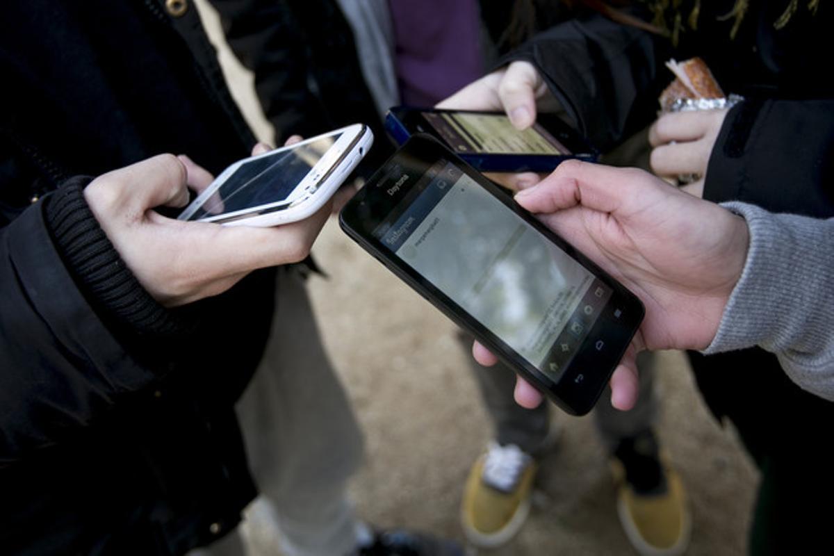 Foto de archivo de unos usuarios utilizando los teléfonos móviles.