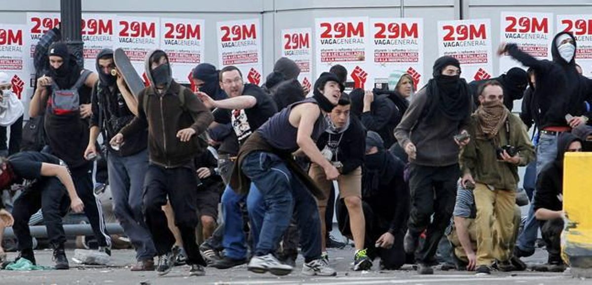 Manifestantes lanzan objetos a la policía durante los disturbios en la jornada de huelga. Manifestantes lanzan objetos a la policía durante los disturbios en la jornada de huelga.