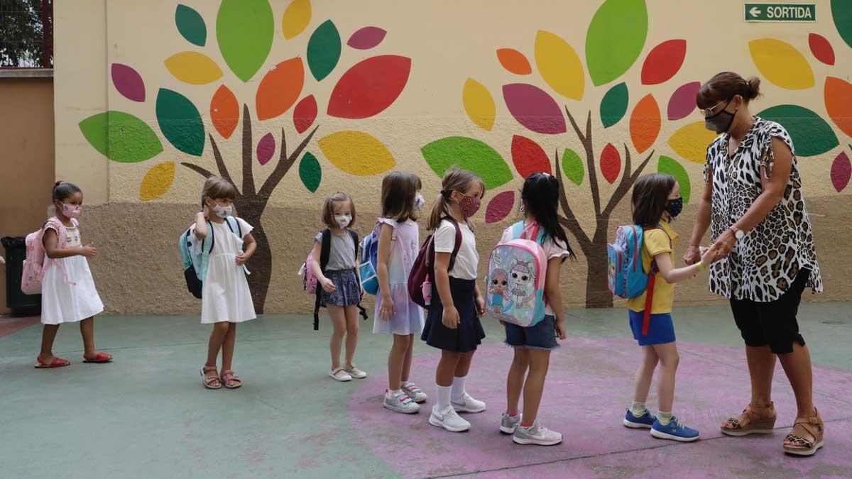 Una profesora recibe a los alumnos de la escuela, en Barcelona.