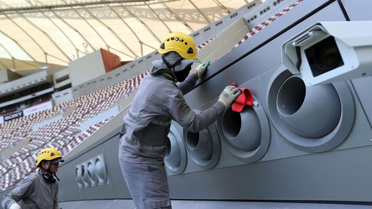 Unos operarios trabajan en la instalación de los sistemas de aire acondicionado en un estadio del Mundial de Qatar.