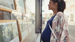 Una embarazada ante el escaparate de una inmobiliaria