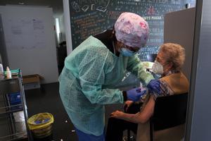 Una mujer recibe la vacuna de la gripe.