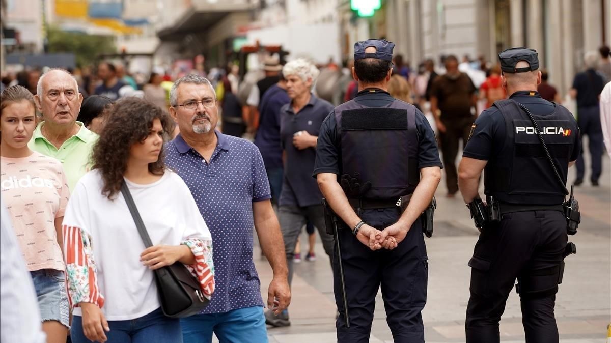Dos policías nacionales patrullan por la calle Preciados, eje comercial y turístico del centro de Madrid. Dos policías nacionales patrullan por la calle Preciados, eje comercial y turístico del centro de Madrid.
