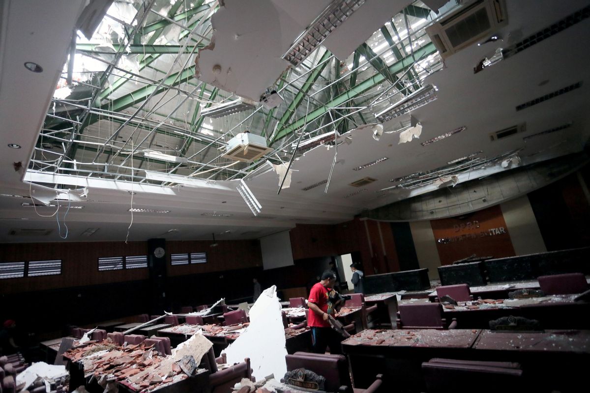 Un hombre recoge los trozos de un edificio dañado por el terremoto en Indonesia Un hombre recoge los trozos de un edificio dañado por el terremoto en Indonesia